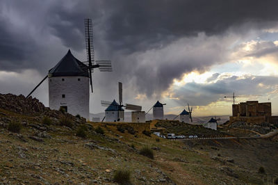 Traditional windmill on street amidst buildings against sky