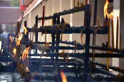 Close-up of candles on railing in temple