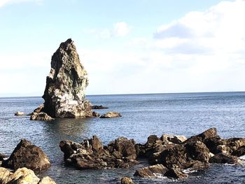 Scenic view of rocks in sea against sky