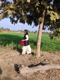 Full length of young woman standing on field