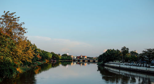 Scenic view of river by trees against sky