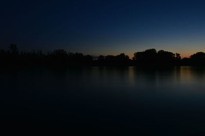 Scenic view of lake against sky at sunset