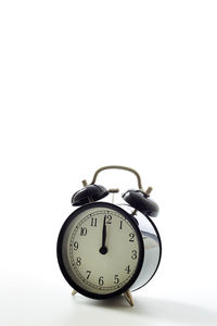 Low angle view of clock on table against white background