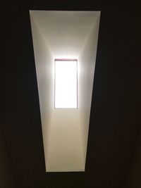 Low angle view of illuminated light bulbs in dark room