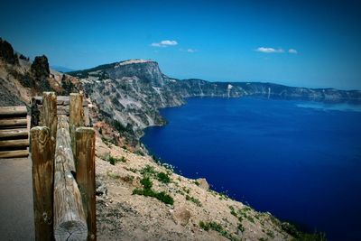 Scenic view of sea and mountains against blue sky