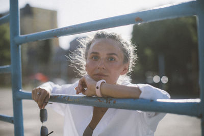 Portrait of woman looking through railing