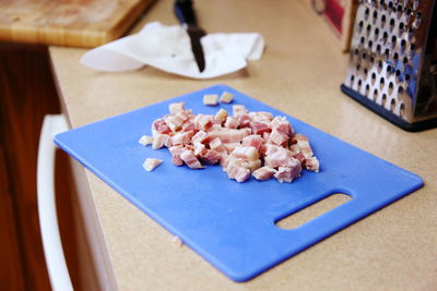 Chopped pancetta on cutting board in kitchen at home