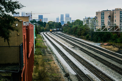 Railroad tracks in city against sky