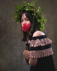 Portrait of beautiful woman standing against red wall