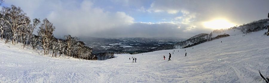 Panoramic view of people on snow covered landscape