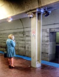 Full length of woman standing on railing