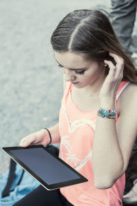 High angle view of female high school student using digital tablet outdoors