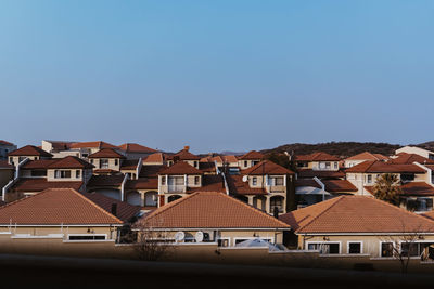 Houses in city against clear blue sky