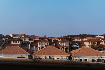 Houses in city against clear blue sky