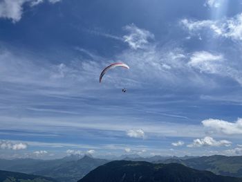 Low angle view of person paragliding against sky