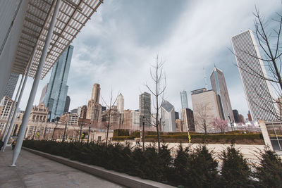 Buildings in city against cloudy sky