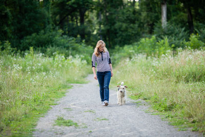 Rear view of woman with dog on street