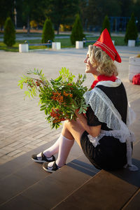 Rear view of woman sitting on floor