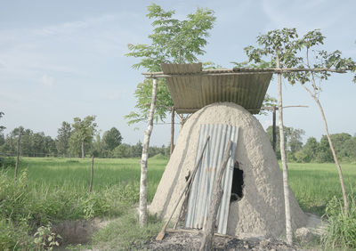 Wooden structure on field against sky