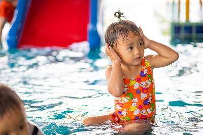 Cute girl sitting in water park