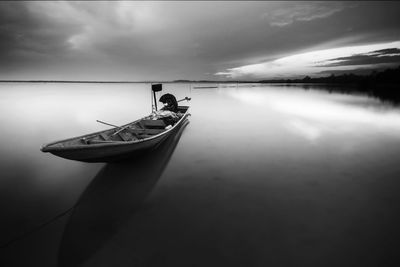 Boat moored in lake against sky