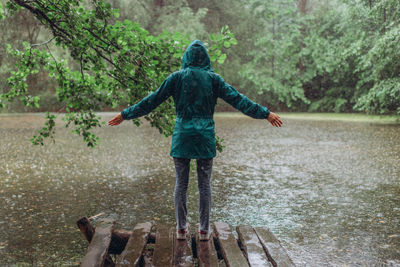 Full length rear view of a man standing in rain