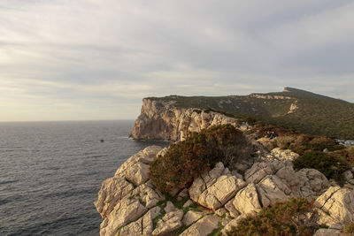 Rock formation by sea against sky