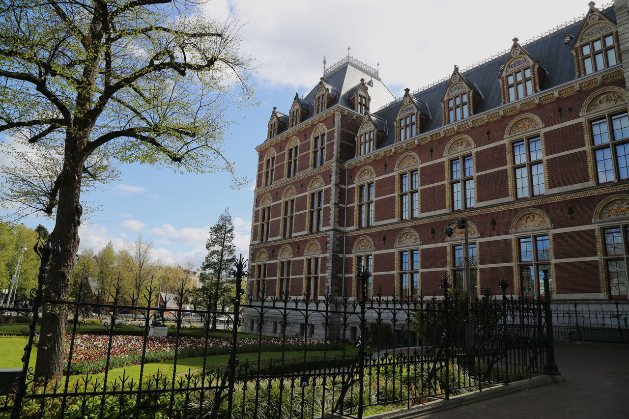 LOW ANGLE VIEW OF BUILDING BY TREES AGAINST SKY