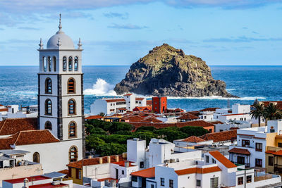 High angle view of townscape by sea against sky