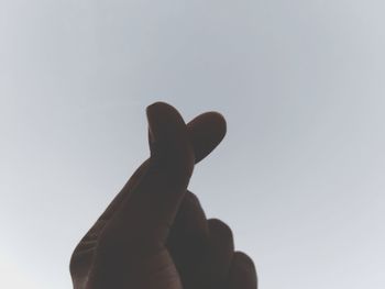 Low angle view of person hand against clear sky