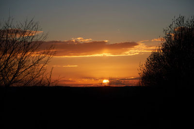 Scenic view of silhouette landscape against orange sky