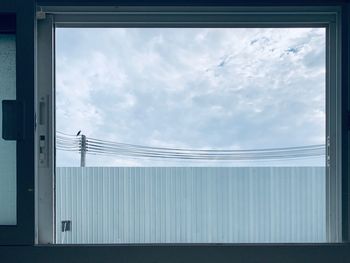 Low angle view of birds on glass window