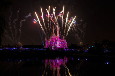 Firework display over lake at night