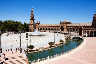 View of canal and buildings against clear blue sky