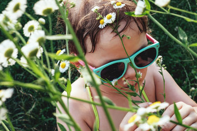 Portrait of a child in sunglasses in daisies flowers. girl sniffing chamomiles. summer time