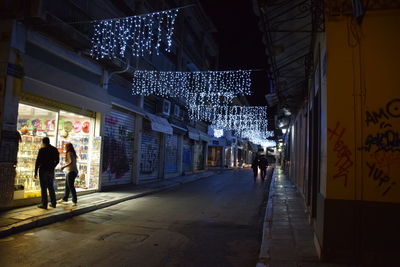 Full length of woman in illuminated city at night