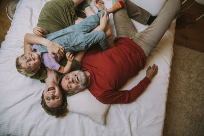 Mother, father and son lying on bed at home