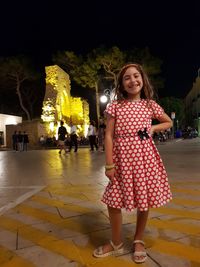 Portrait of smiling girl standing at night