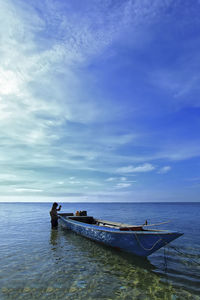 Man on boat in sea against sky