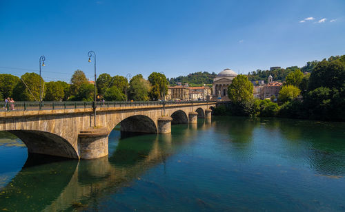 Bridge over river against clear blue sky