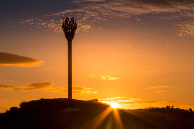 Silhouette plants against orange sky during sunset