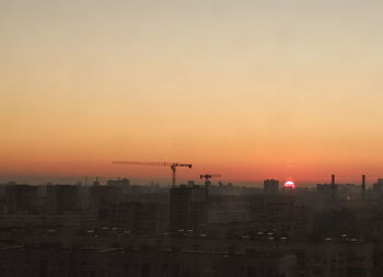 Silhouette buildings against sky during sunset