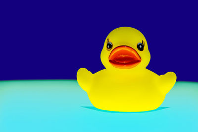 Close-up of yellow toy over blue background