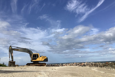 Construction site by road against sky