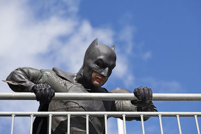 Low angle view of person on railing against sky