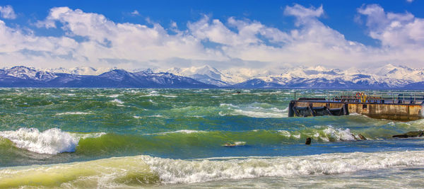 Huge waves crashing over the avacha bay on the stone pier on kamchatka.