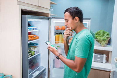 Full length of man standing in kitchen at home