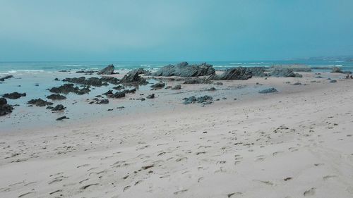 Scenic view of beach against clear blue sky