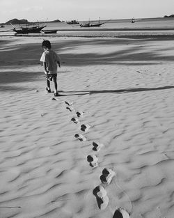 Boy walking on sand at beach