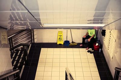 Low section of a janitor sitting at the room corner